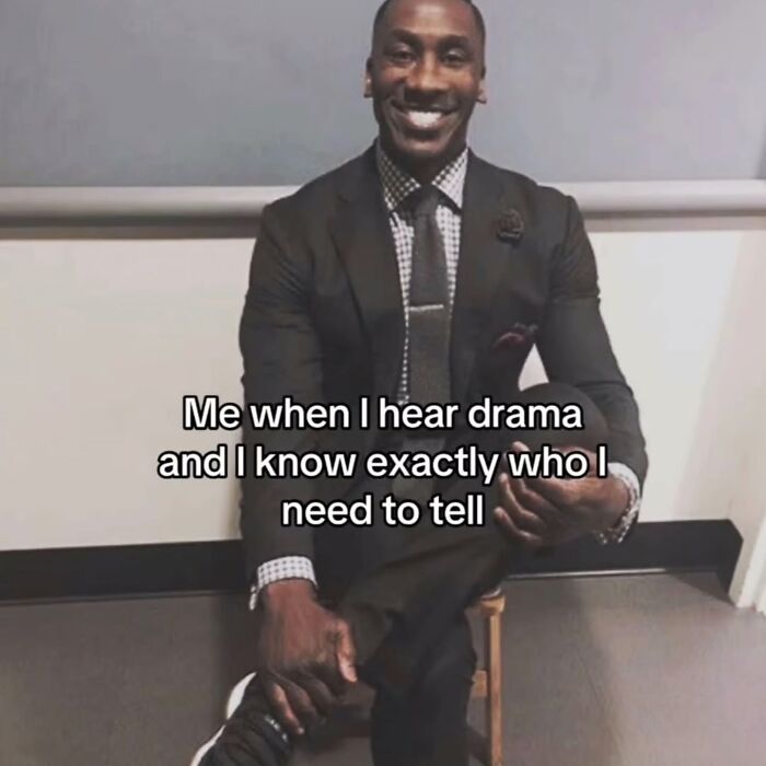 A man in a suit, smiling, with the caption: Me when I hear drama and I know exactly who I need to tell. Relatable meme.