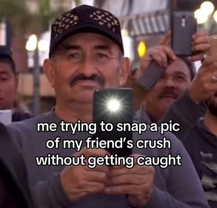 A man secretly taking a photo with a phone, the flash bright, captioned: me trying to snap a pic of my friend's crush without getting caught. Hilarious meme.