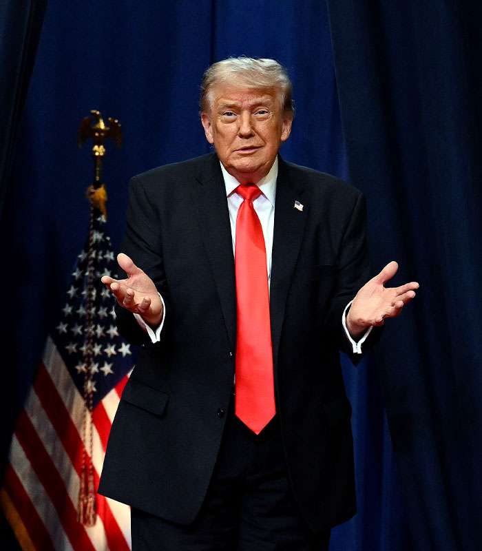 Donald Trump in a suit and red tie, making a gesture with both hands, in a video diagnosing celebrities. Donald Trump in a suit and red tie, making a gesture with both hands, in a video diagnosing celebrities.