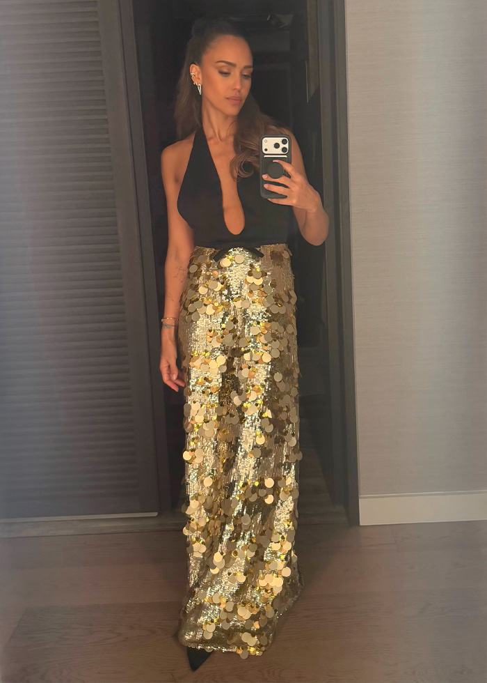 A celebrity guest in a sequined gold skirt and black top, highlighting unique styles at Taylor Swift’s wedding.