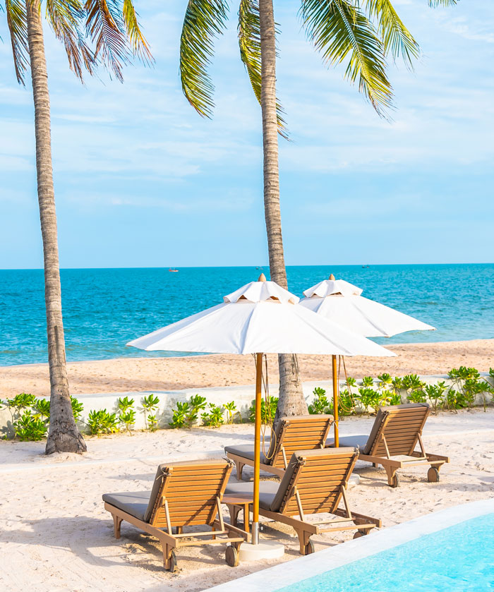 A beautiful beach scene with lounge chairs and umbrellas, representing surprisingly affordable luxury travel.
