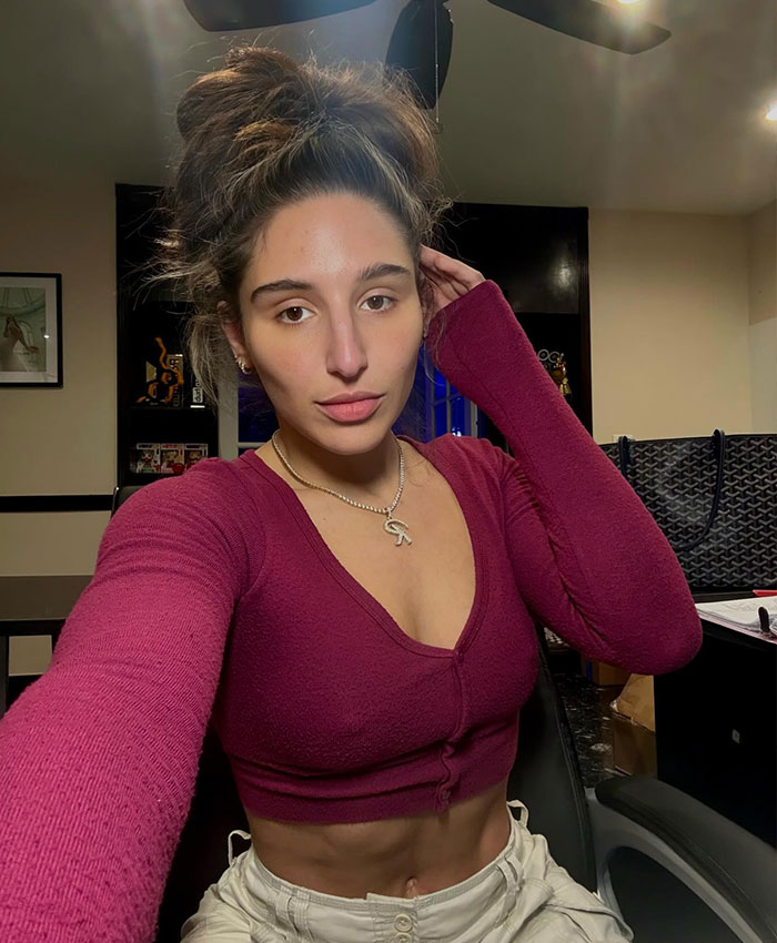 Famous adult star in a burgundy top, revealing her midriff, with hair in a bun, looking at the camera. Famous adult star in a burgundy top, revealing her midriff, with hair in a bun, looking at the camera.