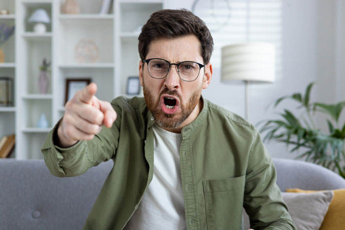A man angrily points, reflecting on why spouses contact a divorce lawyer for non-cheating reasons.