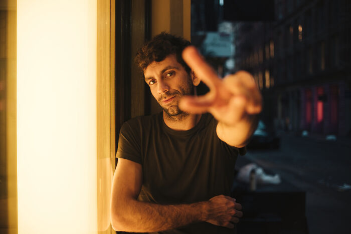 A man making a peace sign with his fingers, perhaps an ironic gesture regarding why people got fired from their jobs.