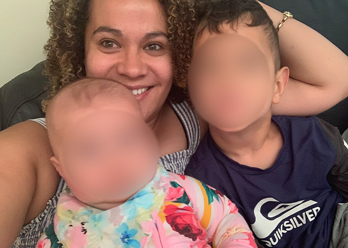 A smiling woman with two children, depicting the mom who lost her life in a marshmallow accident.