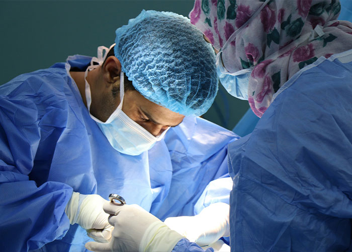 Surgeons performing a cosmetic surgery, emphasizing the serious risks of procedures in private clinics. Surgeons performing a cosmetic surgery, emphasizing the serious risks of procedures in private clinics.