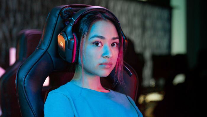 A young woman wearing gaming headphones, looking focused, illustrating stories where people might have overreacted.