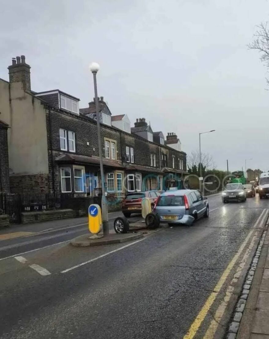 A light blue car had a rough day behind the wheel, losing a wheel in the middle of a street.