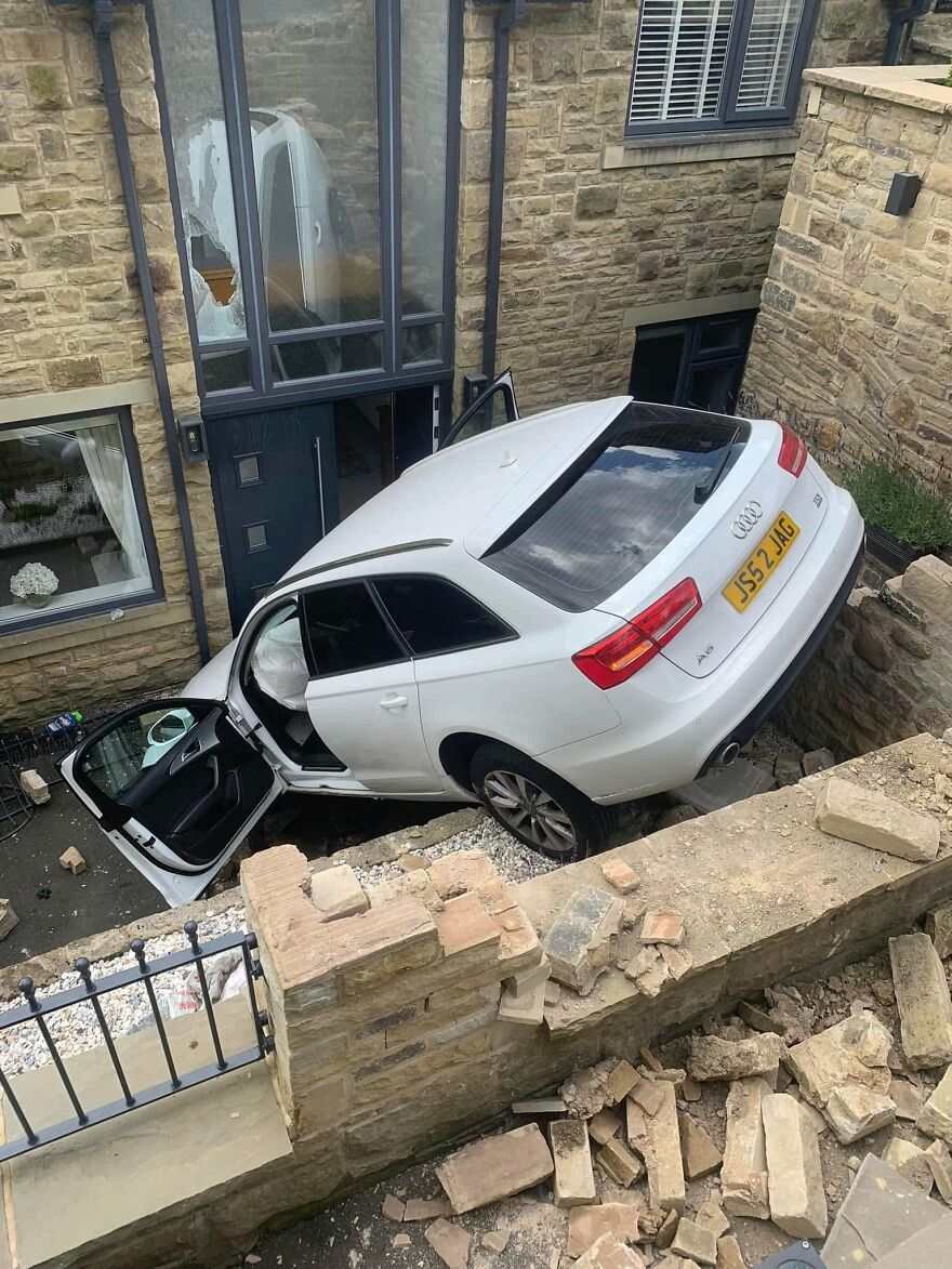 A white Audi wedged into a house entrance, highlighting a rough day behind the wheel for the driver.