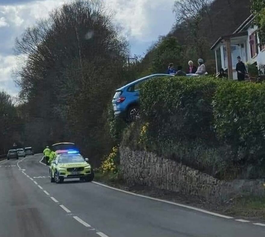 A blue SUV had a rough day behind the wheel, precariously perched on a steep embankment.