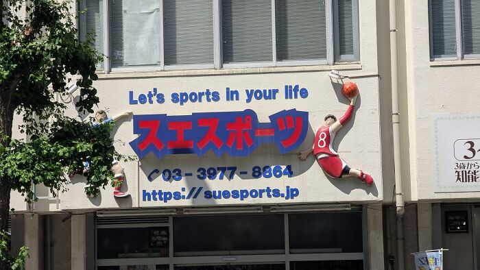The facade of a sports building in Japan with the phrase Let's sports in your life, a hilarious example of getting lost in translation.