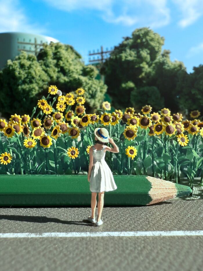 Artist Derrick Lin crafts an intricate diorama set on his office desk, showing a woman in a sunflower field.