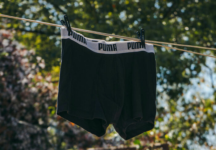 Black boxer briefs hanging on a clothesline outside, hinting at personal stories or house etiquette.