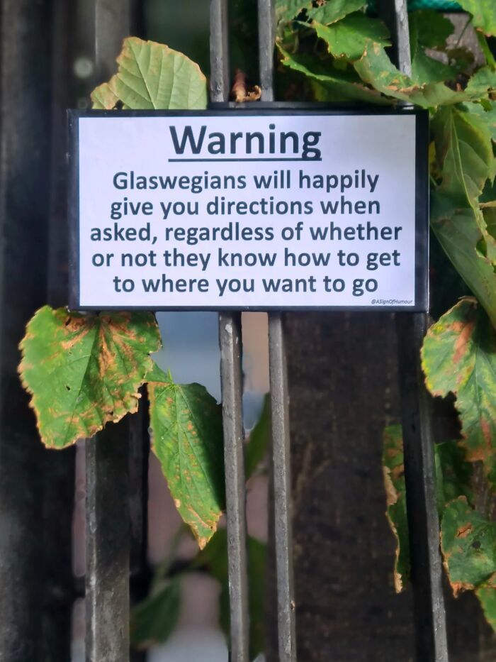 An absurd sign on a metal gate warning about Glaswegians giving directions.