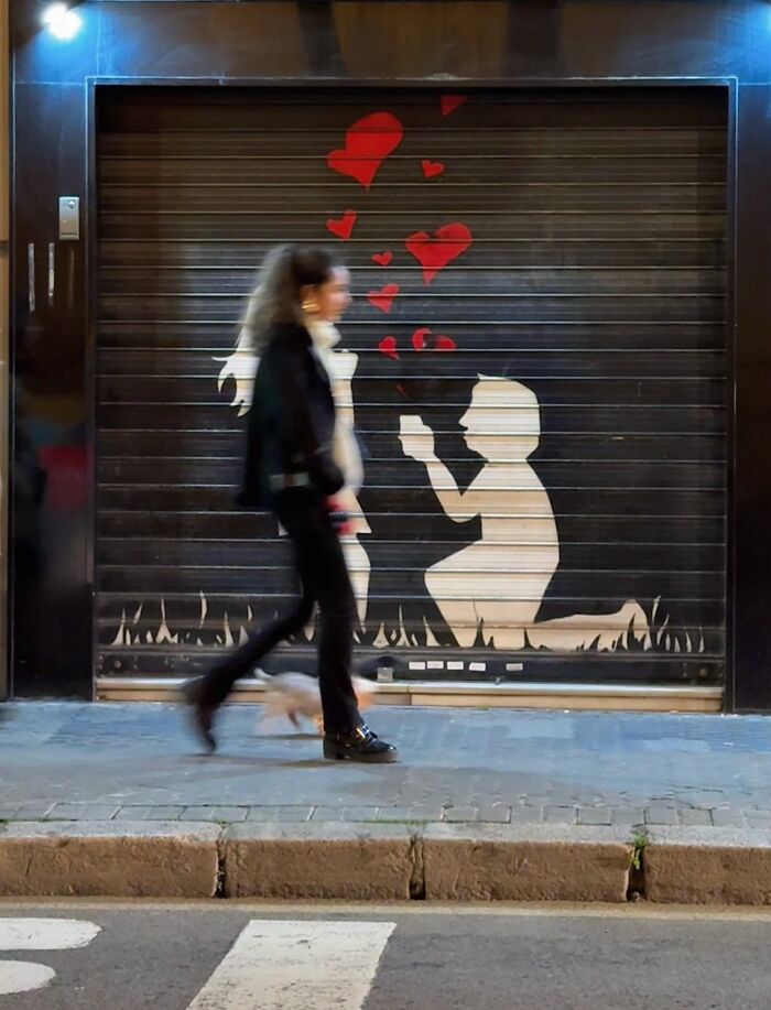 Photographer captures perfectly timed coincidence in Barcelona, where a woman's movement aligns with street art.