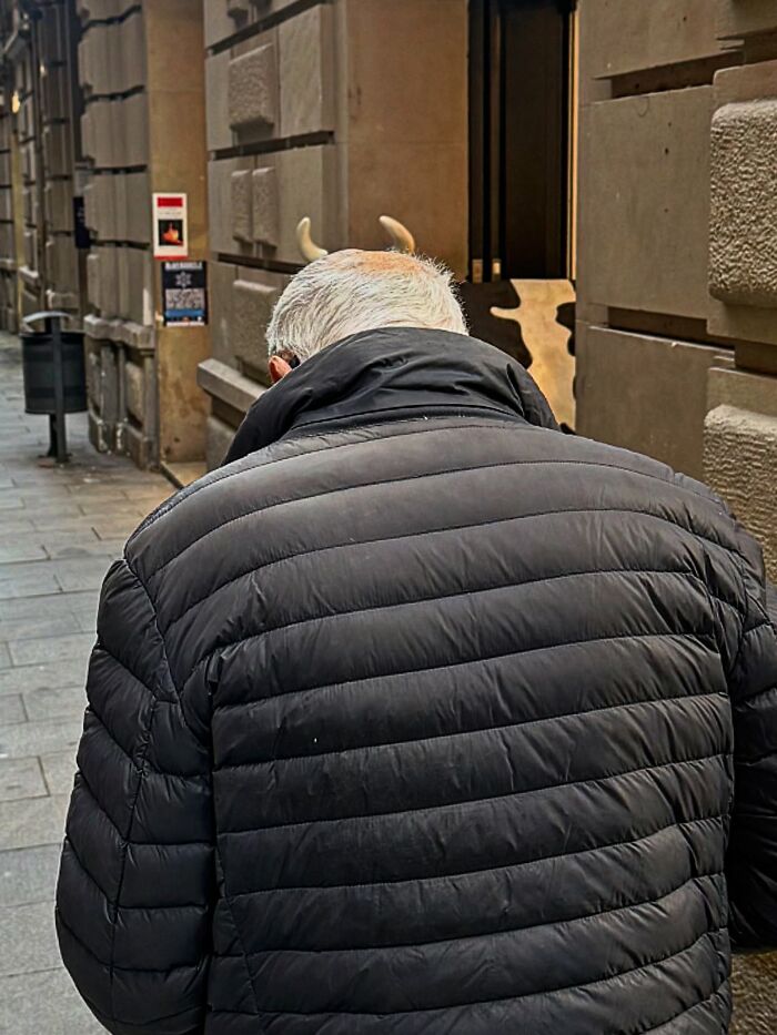 Photographer captures perfectly timed coincidences where a man appears to have horns on his head in Barcelona.