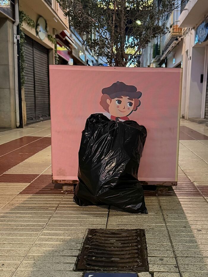 A perfectly timed coincidence in Barcelona shows a black trash bag covering the body of a cartoon character.