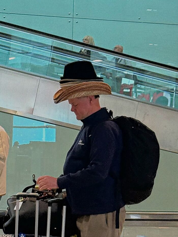 A perfectly timed coincidence in Barcelona shows a man wearing multiple hats stacked on his head.