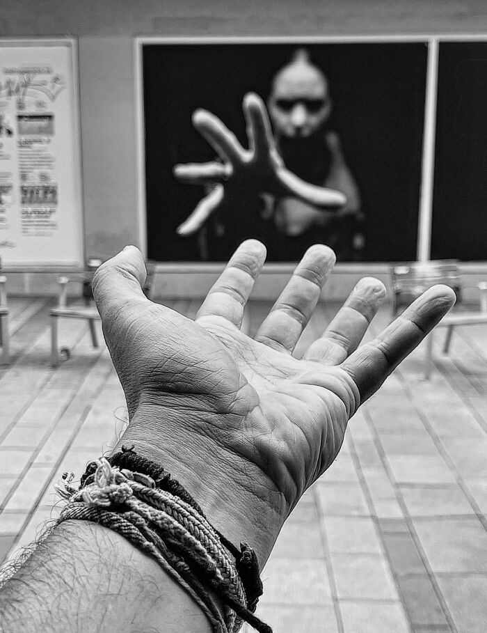 Photographer captures perfectly timed coincidences with a hand reaching towards a poster of a similar reaching hand in Barcelona.