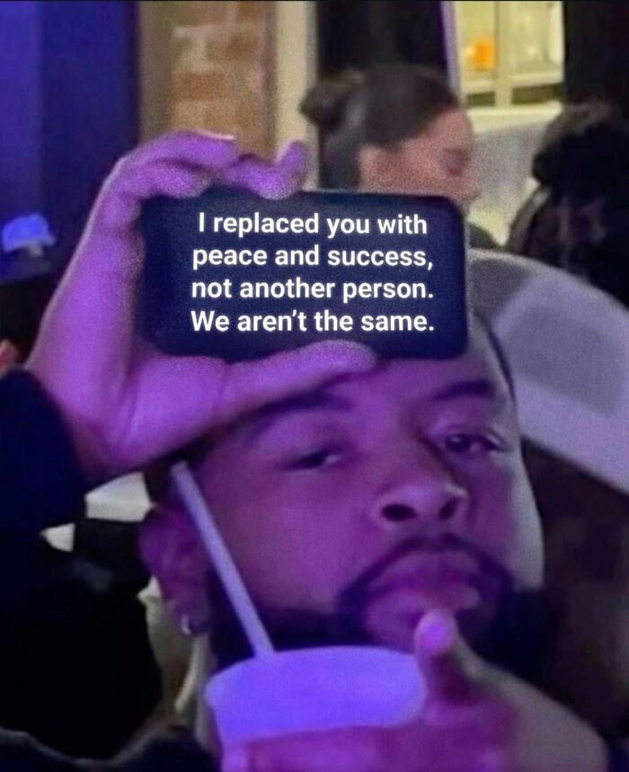 A man holding a phone with a funny post text: I replaced you with peace and success, not another person. We aren't the same. about being a woman.