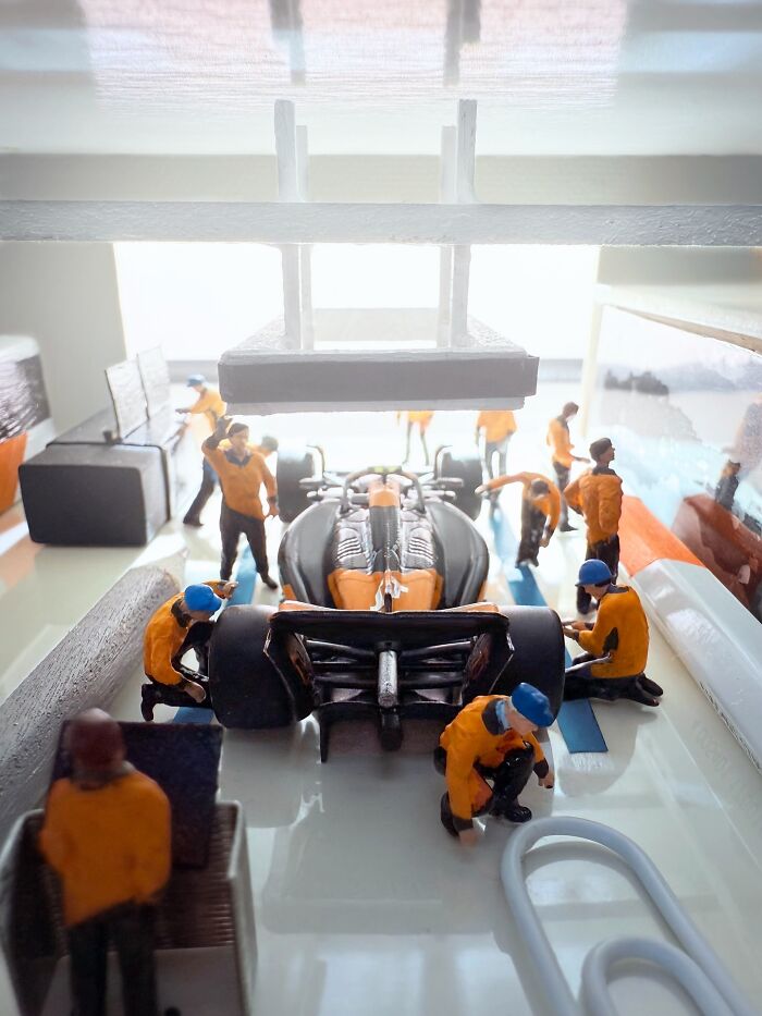 Artist Derrick Lin's intricate diorama set on his office desk depicts a pit crew working on a race car.