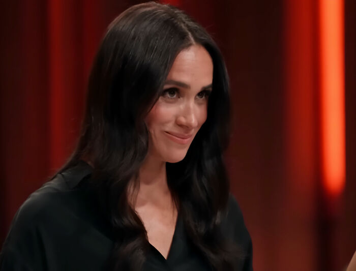 Meghan Markle smiling subtly, facing the camera, amidst discussions of alleged lies about her upbringing. Meghan Markle smiling subtly, facing the camera, amidst discussions of alleged lies about her upbringing.