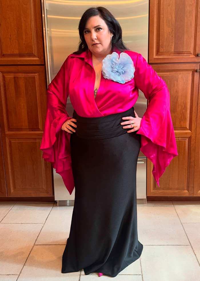 A guest in a vibrant pink top and black skirt, showcasing the varied celebrity wedding fashion at Taylor Swift’s wedding.