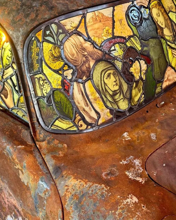 Close-up of the stained-glass sculpture on a rusted Porsche 911, highlighting the detailed artistry.