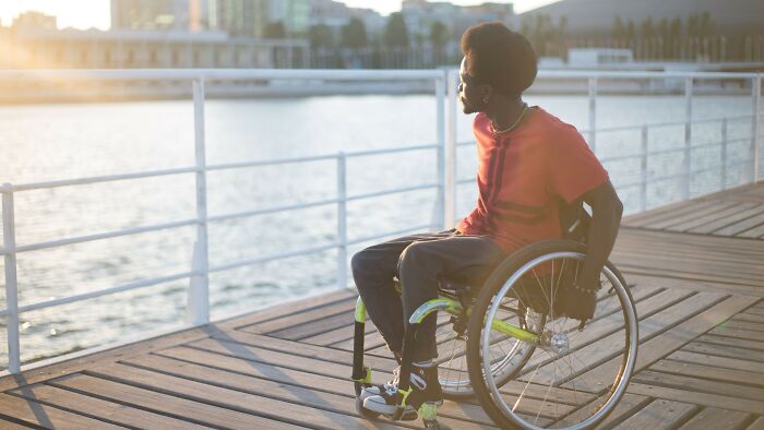 Man in a wheelchair at sunset, reflecting on life-changing accidents and whether he is overreacting to scenarios.