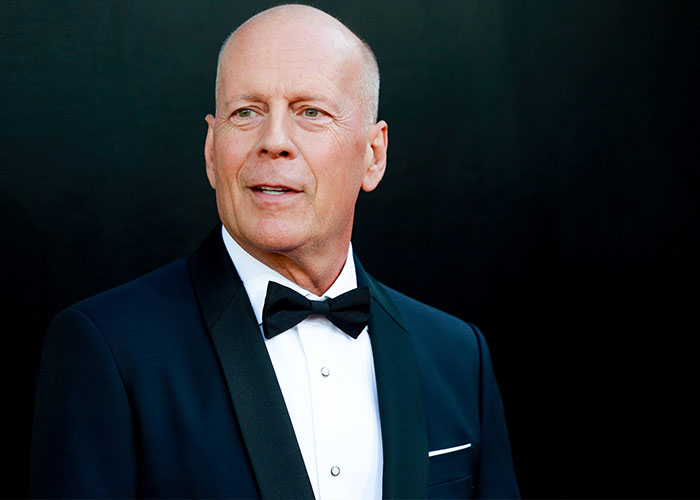 Bruce Willis, dressed in a suit and bow tie, at an event; an image related to dementia awareness. Bruce Willis, dressed in a suit and bow tie, at an event; an image related to dementia awareness.