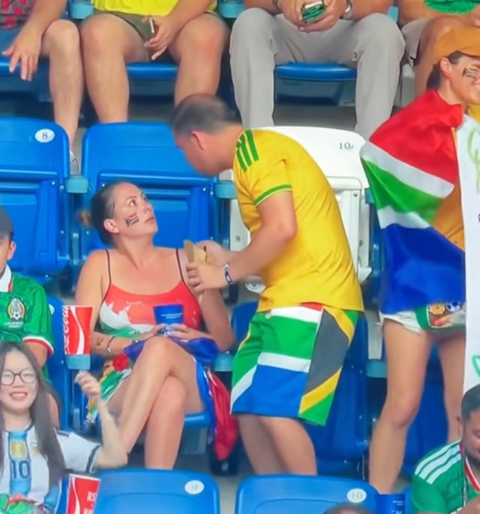 A woman at a World Cup match looks up at a man standing next to her, part of a viral World Cup moment. A woman at a World Cup match looks up at a man standing next to her, part of a viral World Cup moment.
