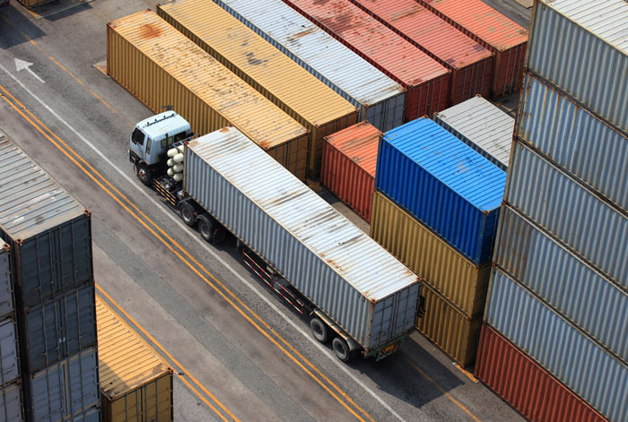 Overhead view of shipping containers and a truck, symbolizing supply chain issues or work stress that could make employees quit job.