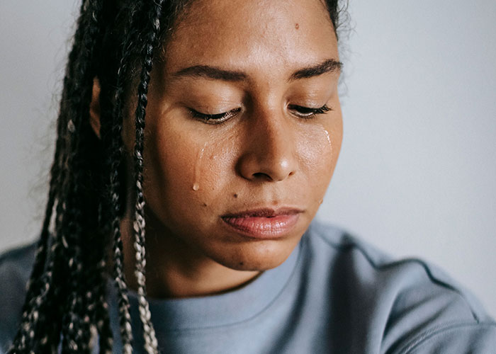 A woman with braids cries, experiencing the loneliest time and not looking forward to her birthdays.