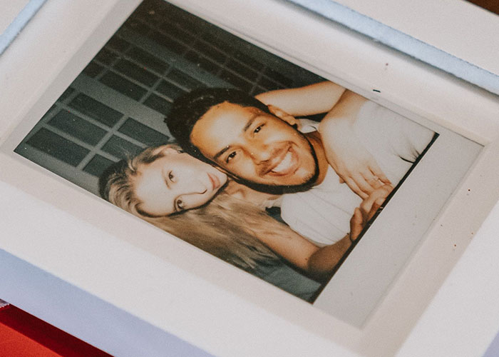 A framed photo of a smiling couple, contrasting with some women's negative experiences at a man's home.