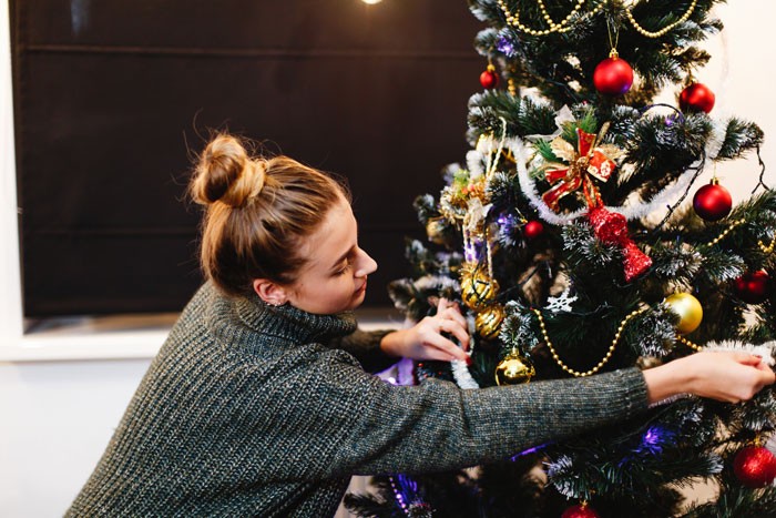 A young woman decorating a Christmas tree, sharing truths women learned.