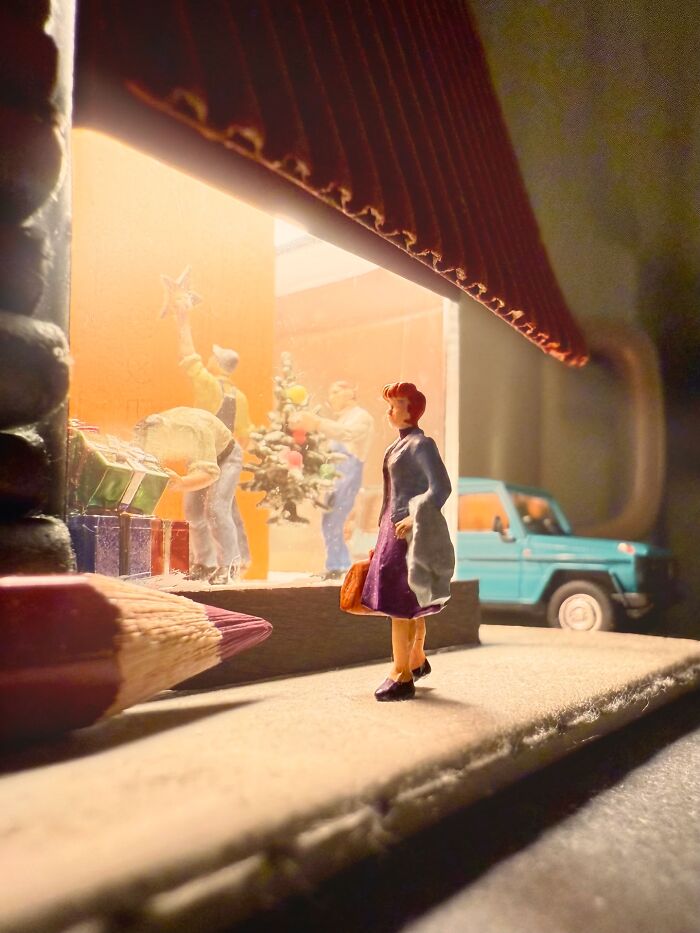 Artist Derrick Lin creates intricate diorama sets of a woman observing a holiday window display.