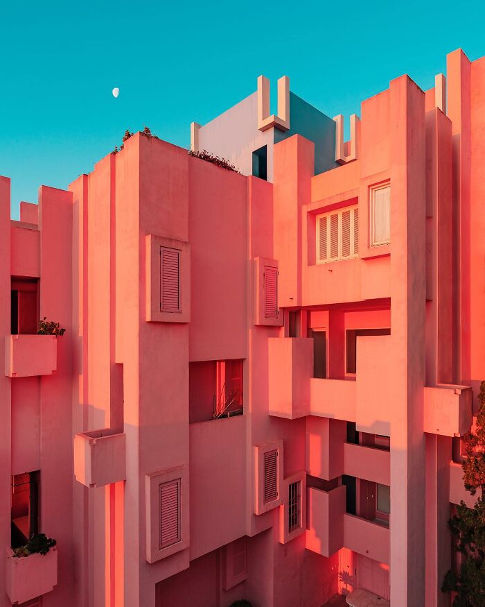 A photographer captures the unique geometry and vibrant pink facade of a building, highlighting its architectural locations.