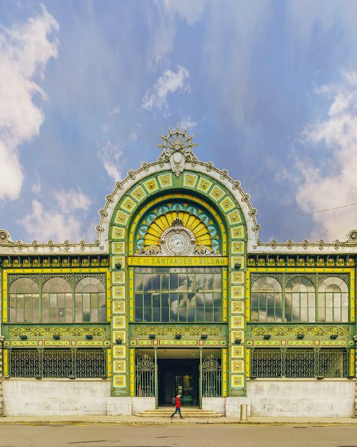 Grand, colorful architectural building with a decorative arch and intricate facade details under a blue sky, showcasing architectural locations.