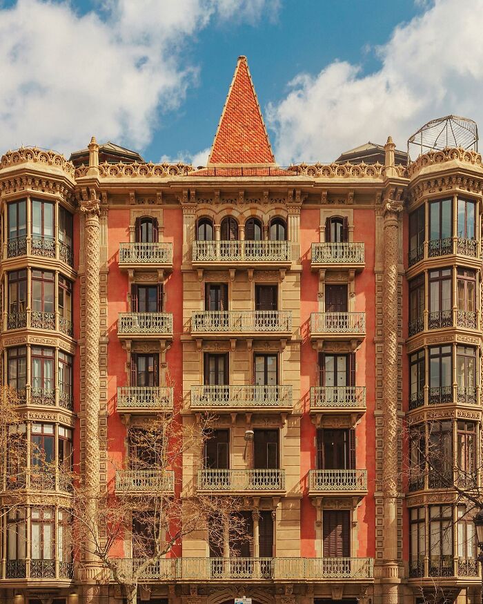 A grand architectural location building with a red-tiled roof, featuring multiple bay windows and balconies under a blue sky.