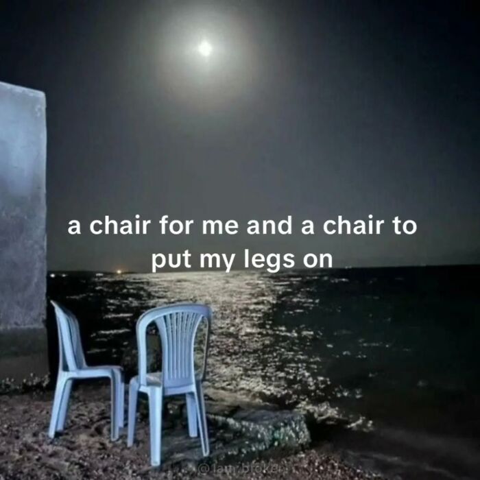 A relatable meme of two chairs by the sea under a full moon, captioned a chair for me and a chair to put my legs on.