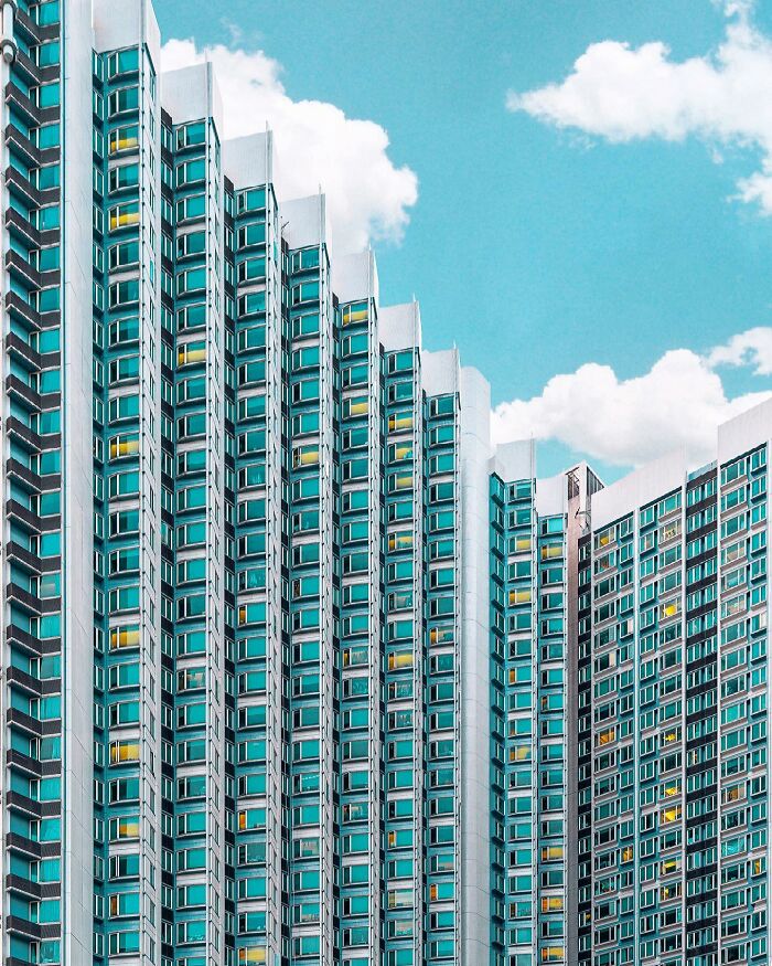 A photographer captures a modern building with many blue-tinted windows, highlighting must-see architectural locations.