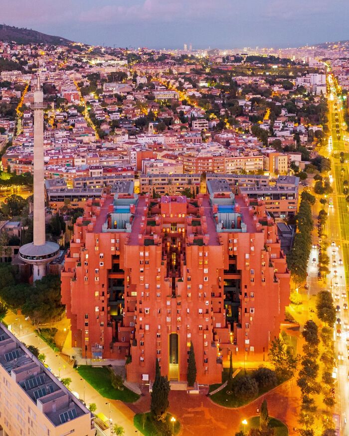 Aerial view of a unique red architectural building in a city at dusk, showcasing architectural locations.