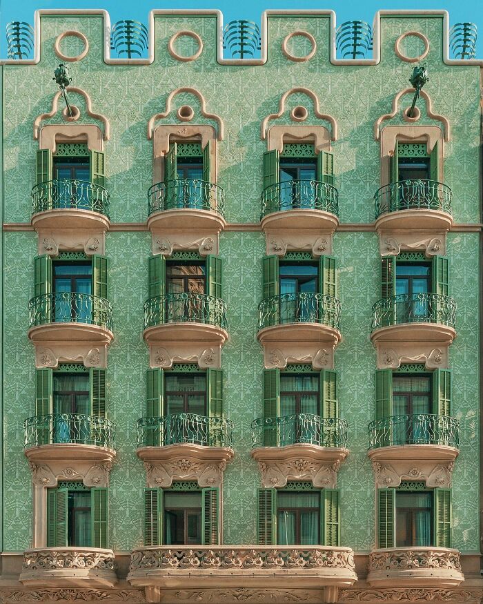 An ornate green building with multiple balconies and decorative details, emphasizing unique architectural locations.