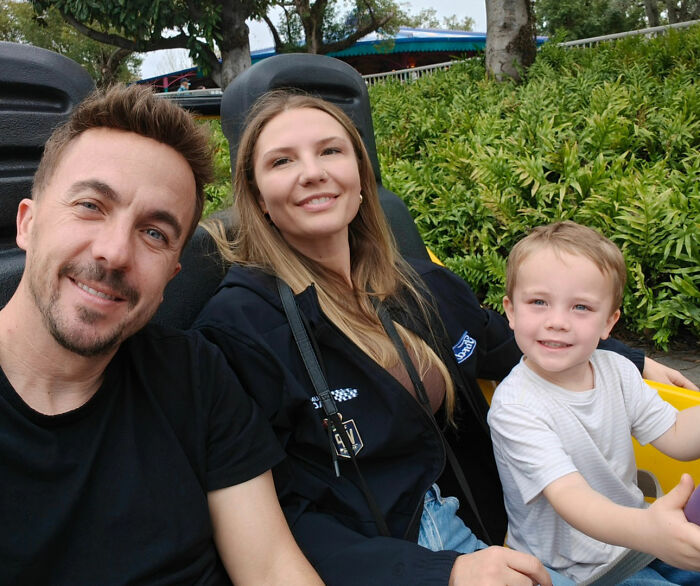Frankie Muniz, his wife Paige, and their child riding a roller coaster together.