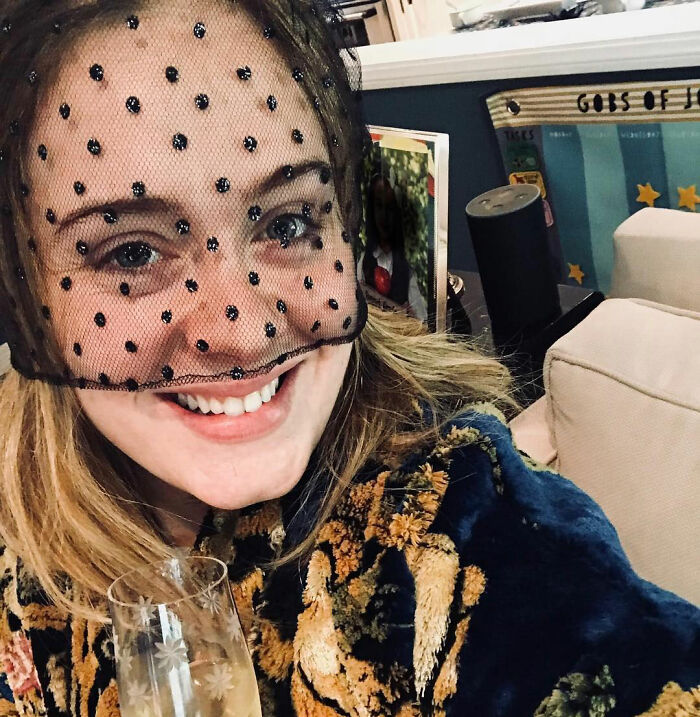Adele smiling with a drink and a netted veil, during a rare public outing. Adele smiling with a drink and a netted veil, during a rare public outing.