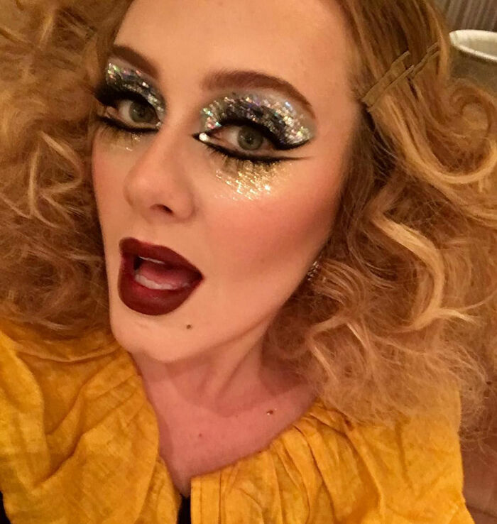 Close-up of Adele's appearance with dramatic glittery eye makeup and dark lipstick. Close-up of Adele's appearance with dramatic glittery eye makeup and dark lipstick.