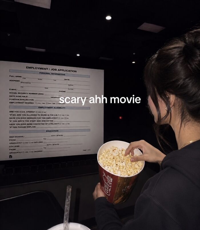 A person eating popcorn while looking at a scary job application, a relatable meme to boost morale.