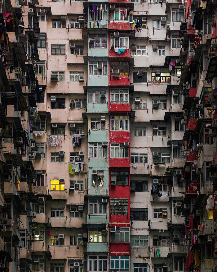A dense urban architectural location featuring many apartment windows and a red central building section.