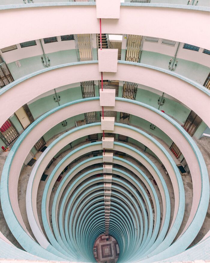 A perfectly composed image of a circular architectural structure looking down, revealing multiple levels of balconies.