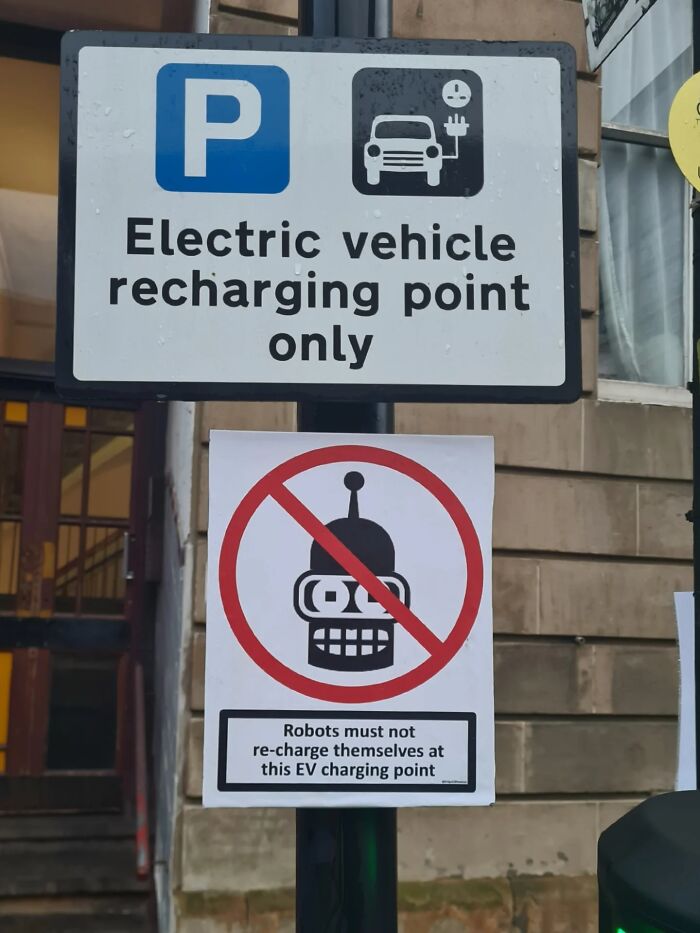 Absurd signs: A humorous sign prohibiting robots from recharging at an EV charging point.